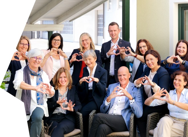 Gruppenbild der TRAIN GmbH, auf dem alle mit den Händen ein Herz formen