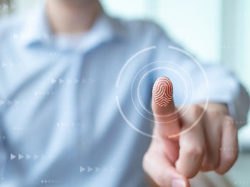 Ein Zeigefinger zeigt auf einen Fingerabdruck an einer gläsernen Wand